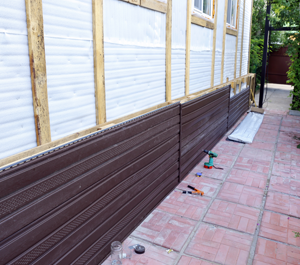 A Wooden Fence Is Under Construction Around A House