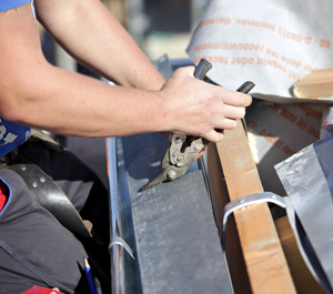 A Man Using A Cutting Tool To Slice Through A Piece Of Metal